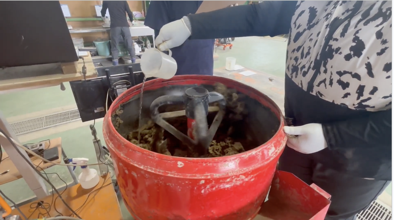 土砂に材料を加えながら配合試験を行っている作業の様子