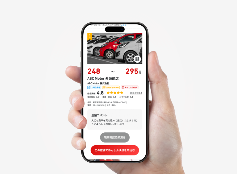 手に持ったスマートフォンに、MOTA車買取の査定価格と店舗情報が表示されている画面