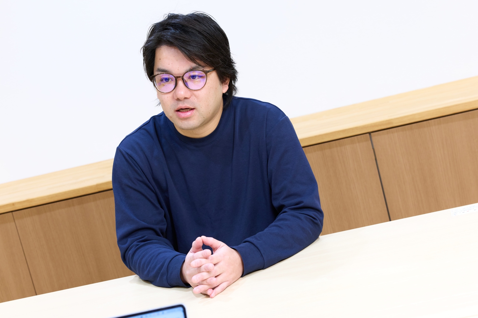 テーブルを挟んで話す株式会社NERON代表取締役の長﨑恭久氏
